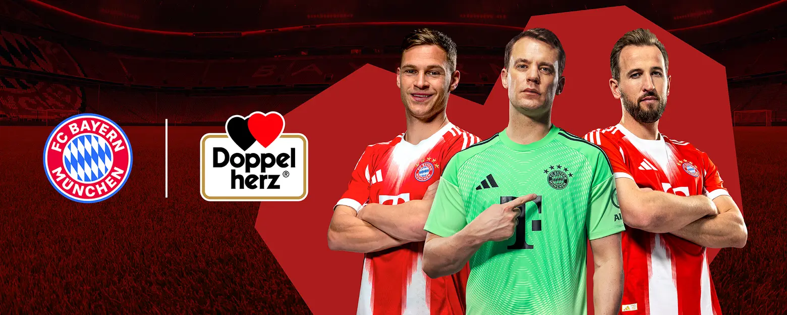 Tiga pemain FC Bayern München berdiri berdampingan di lapangan sepak bola. Mereka mengenakan jersey merah dengan logo klub. Pemain di tengah adalah penjaga gawang, mengenakan seragam hijau. Di sebelah kiri dan kanan, dua pemain lain tersenyum dan menunjukkan sikap percaya diri.